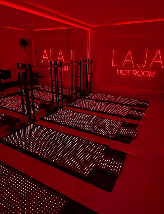 Hot Room de LAJA con tapetes de luz infrarroja y letrero de neón